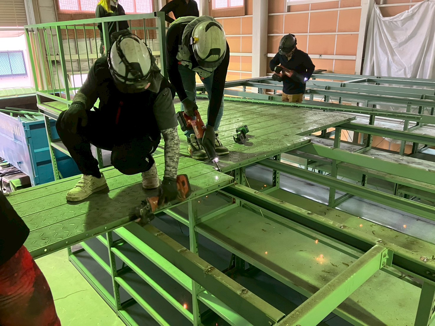 工具を使用した工場内積層ラック天板の切断解体風景